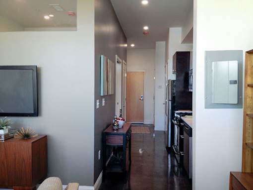 Modern entryway with dark accent wall and hardwood floors at 68 Beale Apartments, Massachusetts